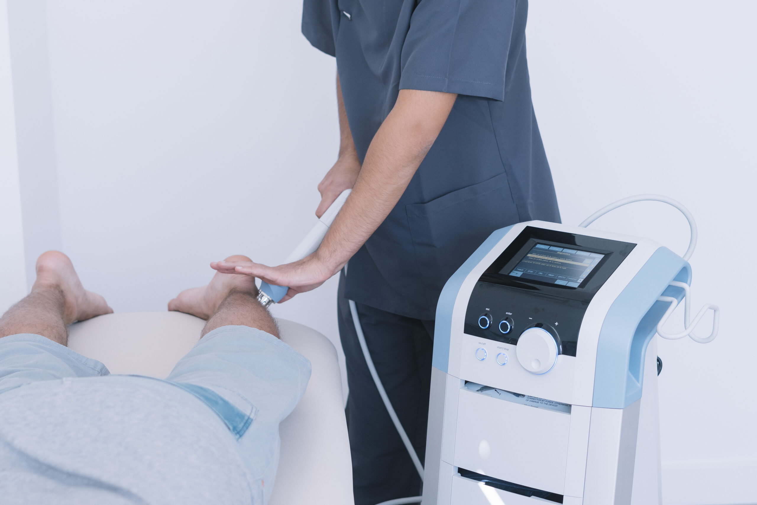 The physiotherapist treating a man using equipment for radio therapy